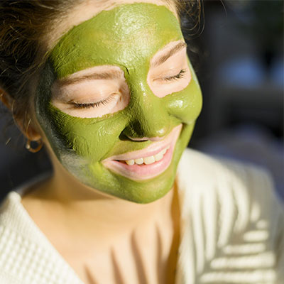 femme souriante avec son masque beauté du visage